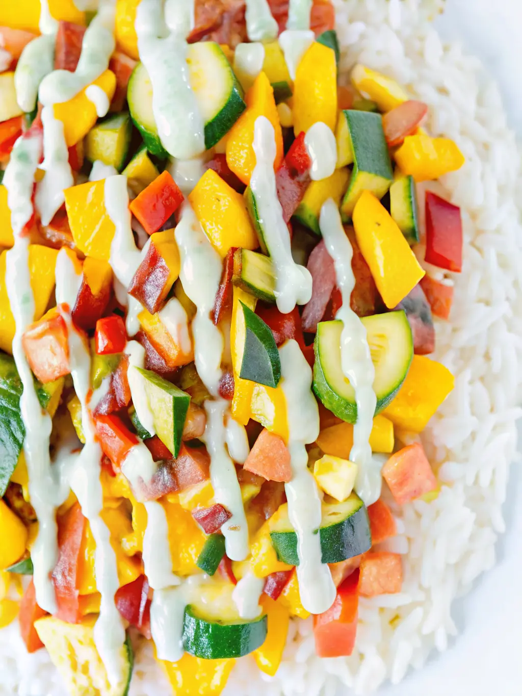 A small, high-speed blender containing the vibrant light green mixture of Green Onion Cashew Sauce in mid-blend, showing the creamy texture forming. The blender is positioned on a white marble countertop with soft natural light, and fresh green onions are nearby. No hands visible.