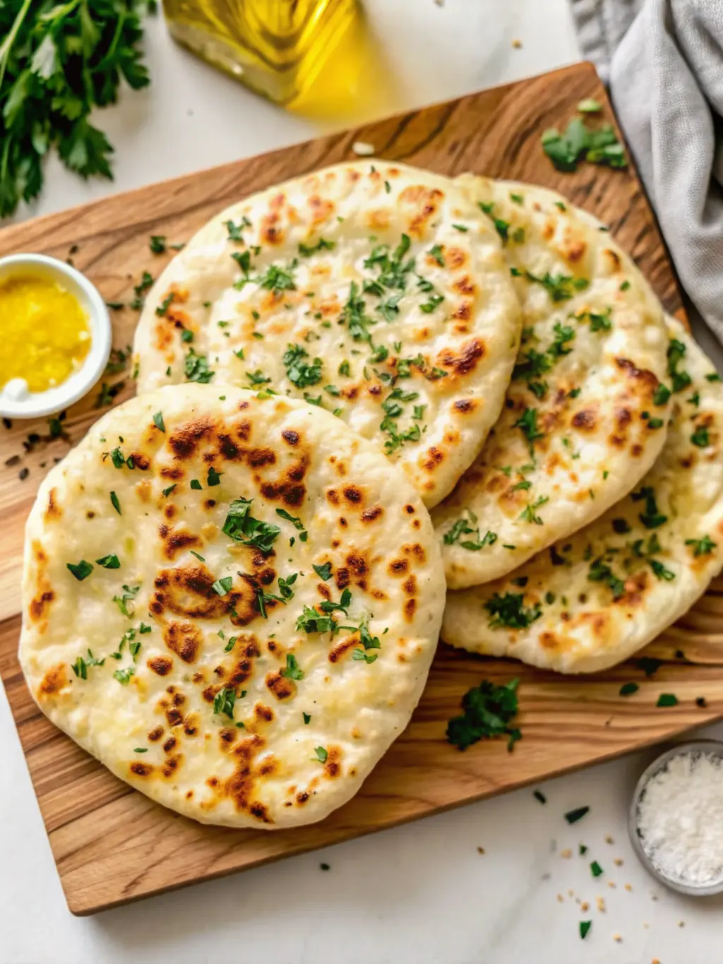 A close-up shot of a single fluffy cottage cheese flatbread cooking in a hot cast-iron skillet, showing it gently puffing up and developing golden-brown blisters. The pan is on a stove burner on a white marble countertop. Soft natural morning light, warm tones, minimal background elements. (3:4 ratio).