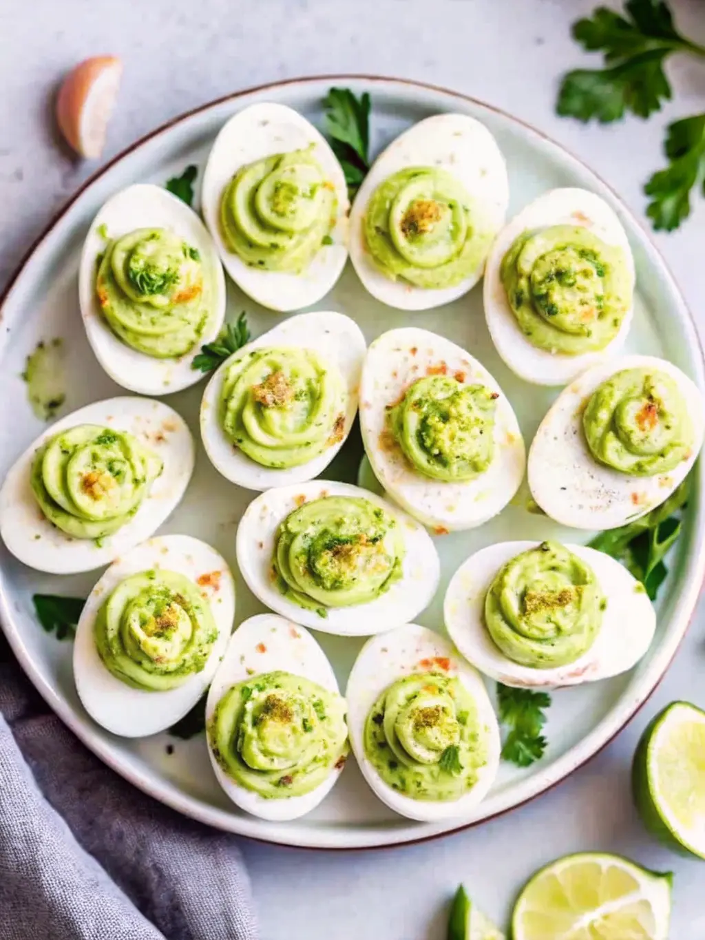 A 3:4 ratio image showing a collection of ingredients for Million Dollar Deviled Eggs: a bowl of peeled hard-boiled eggs, a jar of mayonnaise, a tube of Dijon mustard, a bottle of apple cider vinegar, a small bowl of smoked paprika, and fresh chives on the same wooden cutting board. All are arranged neatly on a marble countertop with natural morning light and soft shadows. NO HANDS OR PEOPLE.