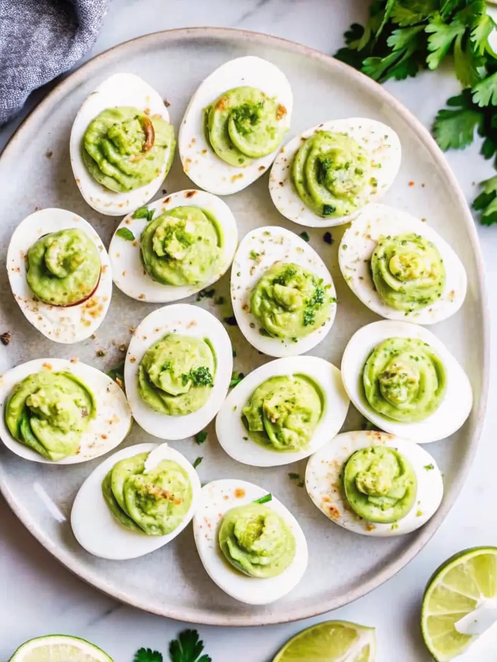 A 3:4 ratio image capturing the process of making Million Dollar Deviled Eggs: A medium ceramic bowl on a marble countertop containing mashed egg yolks mixed with mayonnaise and seasonings, being vigorously whisked with a stainless steel whisk. In the background, there are egg white halves waiting on a minimalist white plate. The lighting is natural morning light, creating a clean and tidy look. NO HANDS OR PEOPLE.