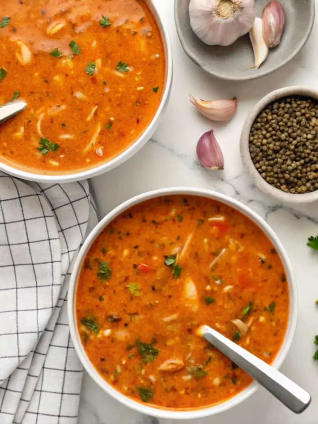 A close-up (3:4 ratio) of fresh ingredients for Vegan Creamy Italian Cabbage Soup spread on a bright marble countertop: thinly sliced green cabbage, a pile of green lentils, whole garlic cloves, fresh parsley, and a can of crushed tomatoes, all bathed in natural morning light. The same rustic white wooden cutting board is partially visible. NO HANDS OR PEOPLE.