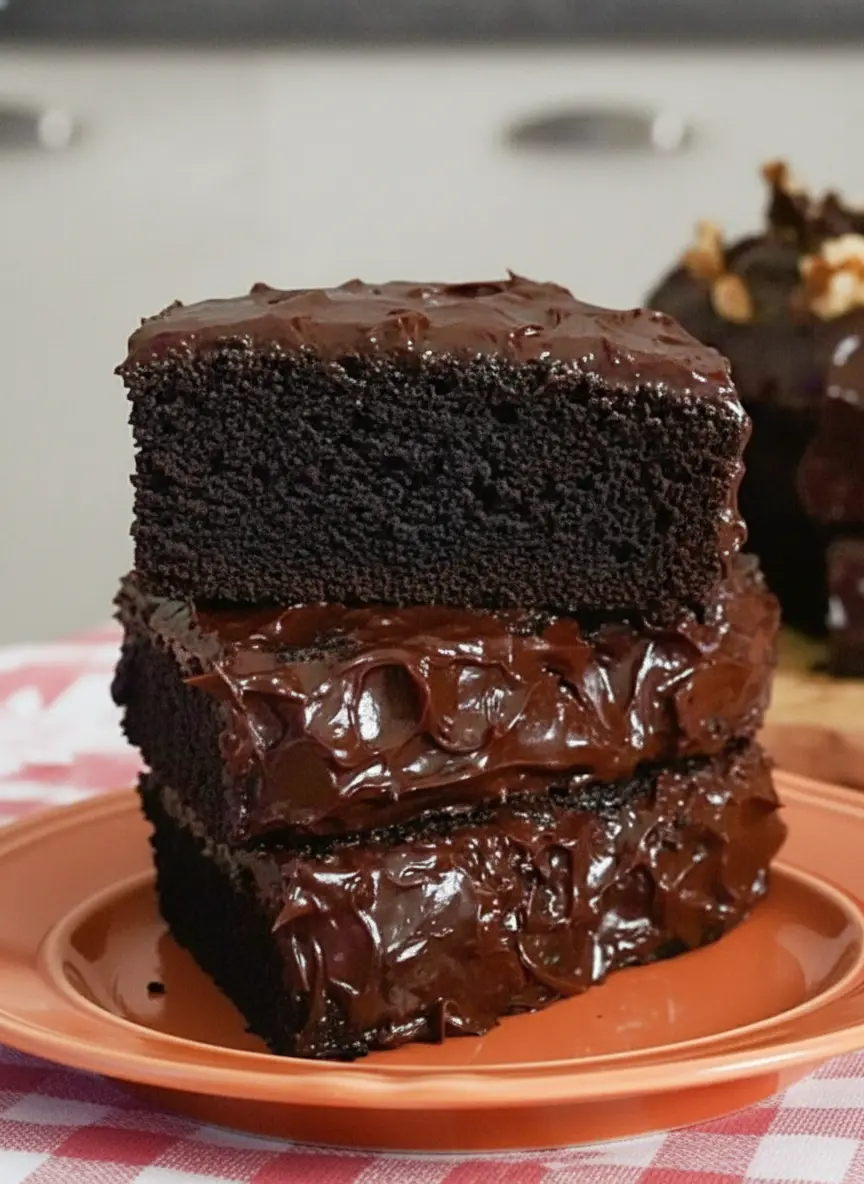 A dark, glossy chocolate banana cake batter with rich swirls being poured into a greased baking pan resting on a wooden cutting board. Deep chocolate textures are visible in the smooth batter, captured in natural, soft kitchen light.